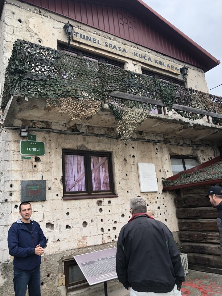 Bâtiment avec un filet de camouflage et des impacts de balles.