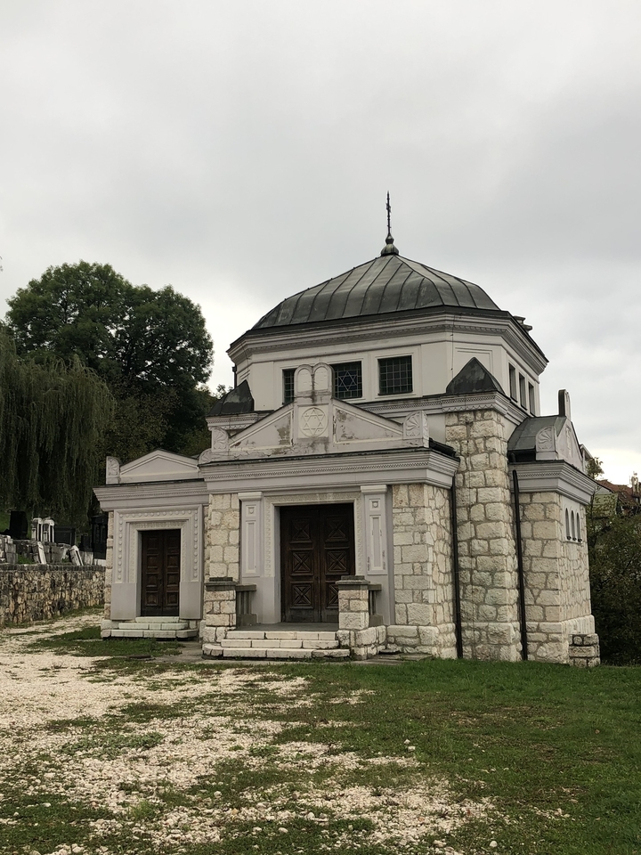 Petit bâtiment en pierre avec un dôme et une architecture détaillée.