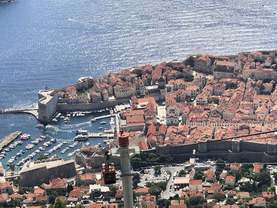 Vue aérienne d'une ville côtière historique avec un port de plaisance.