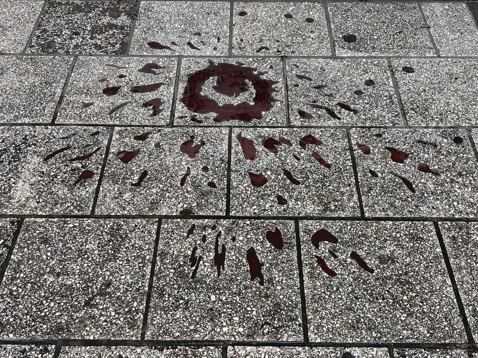 Trottoir en béton avec des taches rouges mystérieuses.