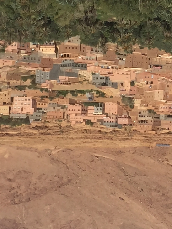A distant view of a traditional desert village with flat-roofed buildings.