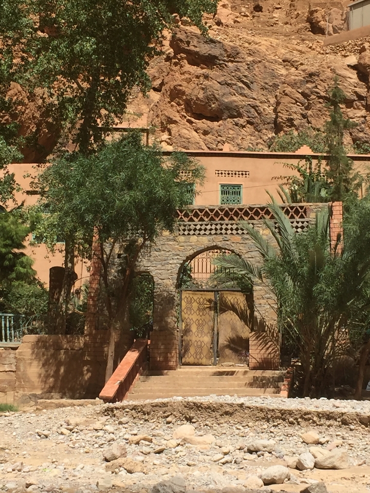 A view of a traditional Moroccan building facade with decorative patterns and plants.