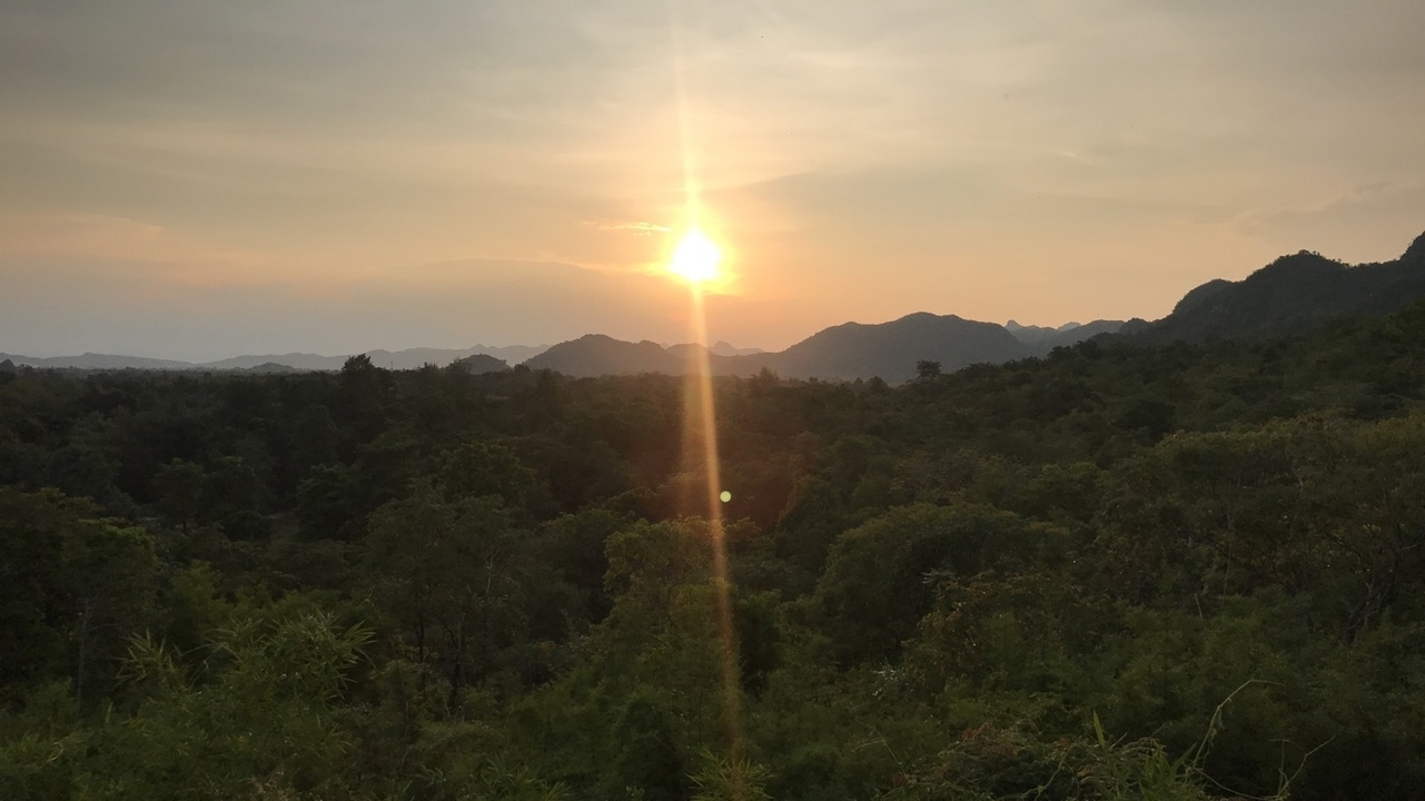 Sunset over a forested landscape.