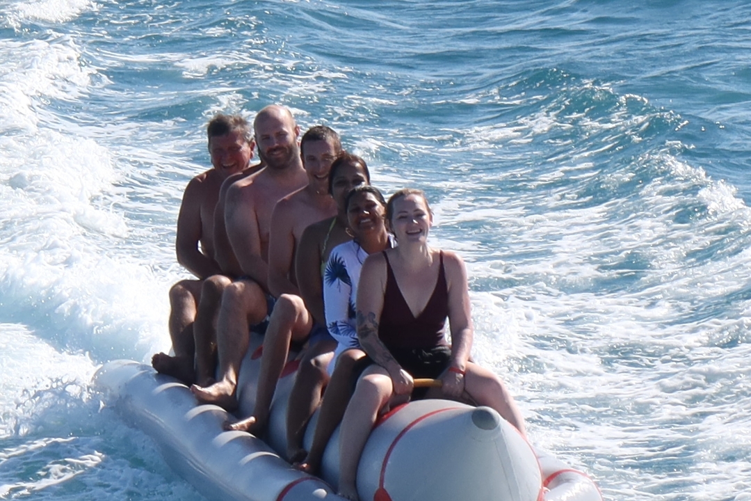 Groupe de personnes faisant du bateau banane sur la mer.