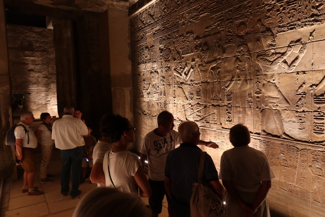 Groupe observant d'anciens hiéroglyphes sur les murs du temple.