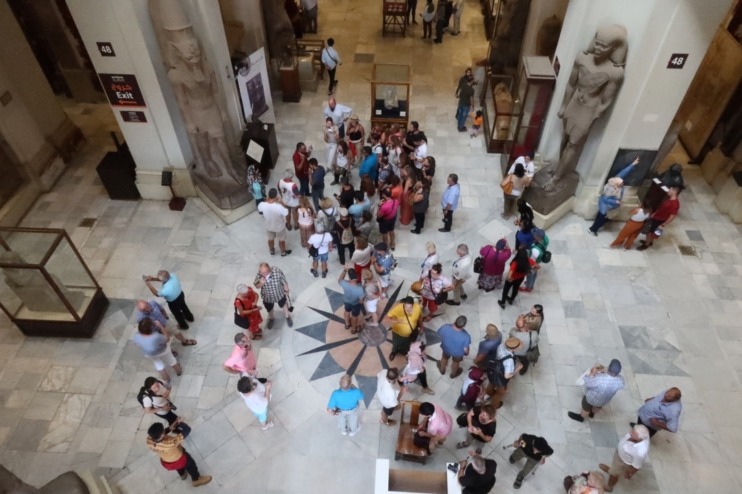 Foule rassemblée dans un musée intérieur autour d'une exposition.