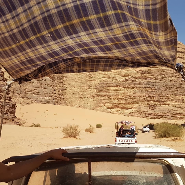 Vehicle driving through a rocky desert landscape.
