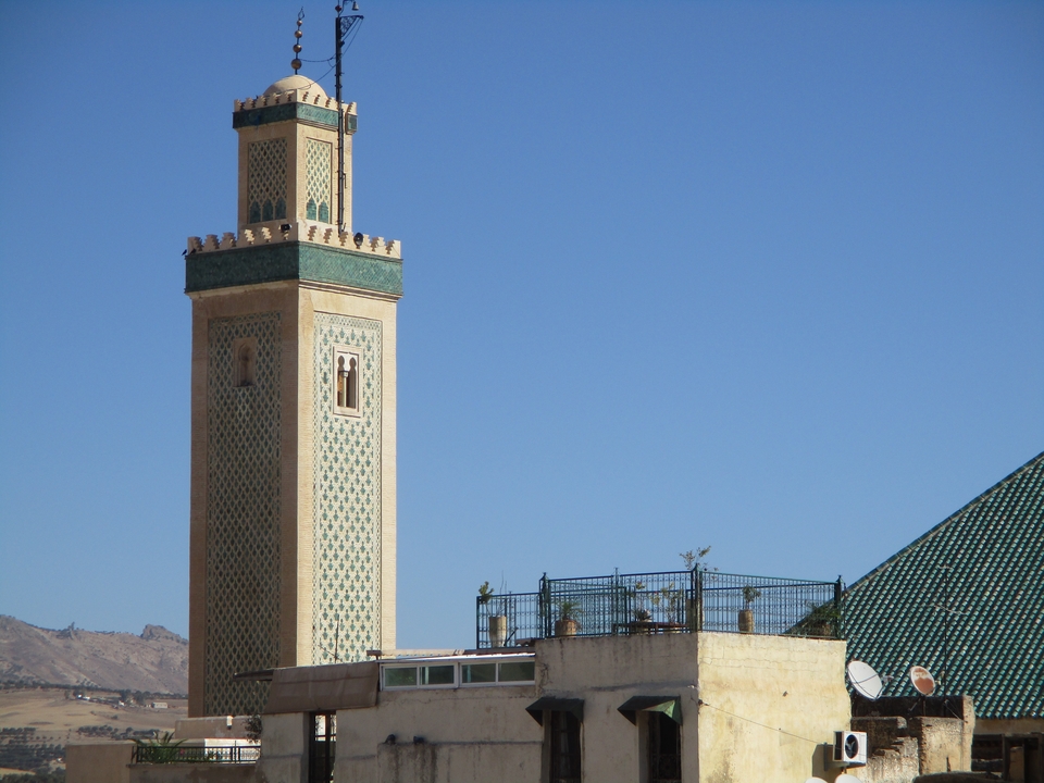 Ornate minaret against a clear blue sky.