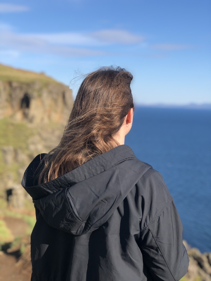 Person looking at the sea from a cliff.