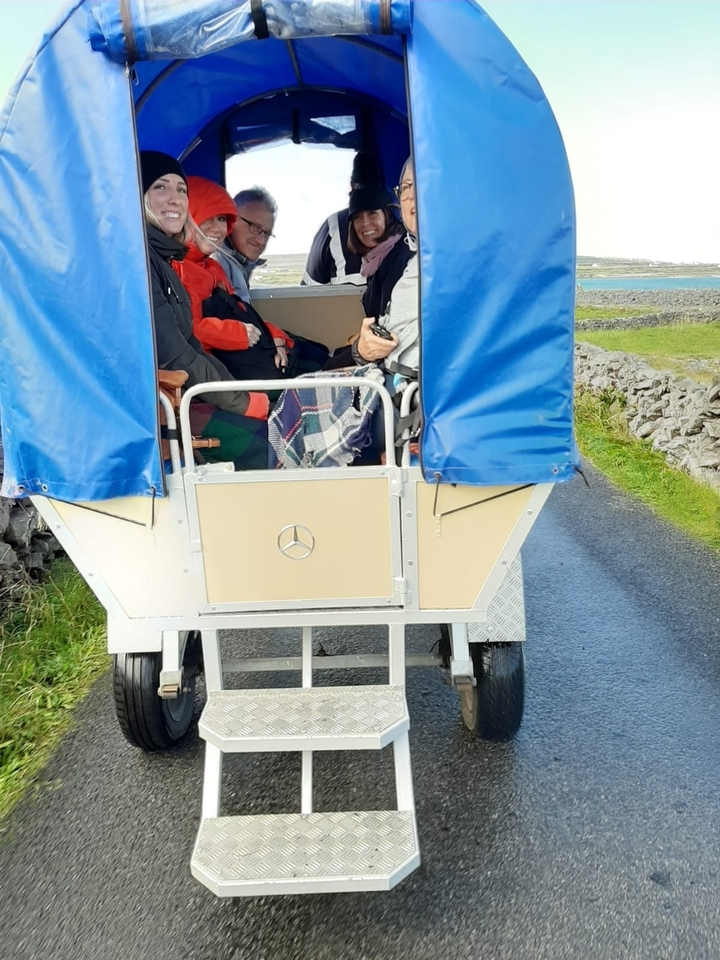 Des gens dans une calèche tirée par des chevaux.