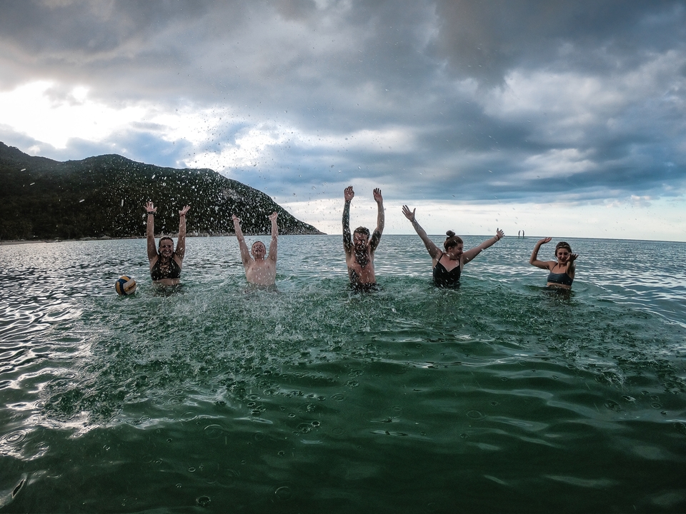 Group of people splashing water while posing.