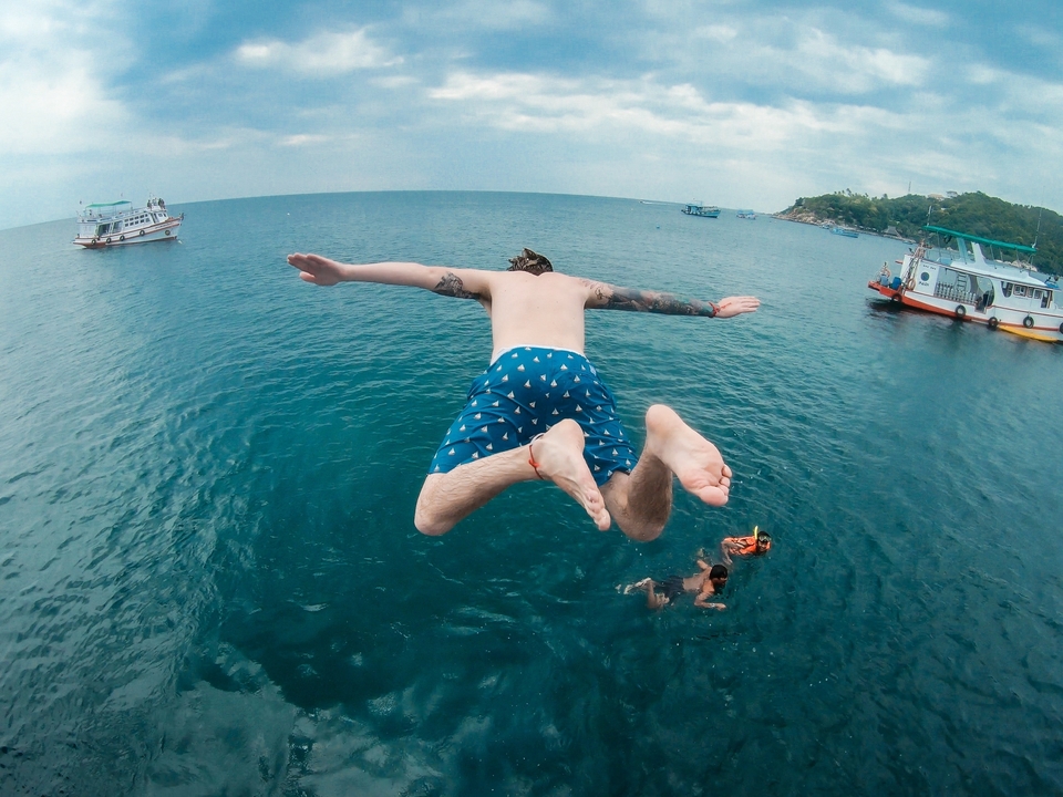 Person diving into the ocean from a boat.