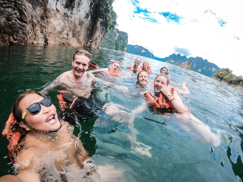 Group posing in water in life jackets.