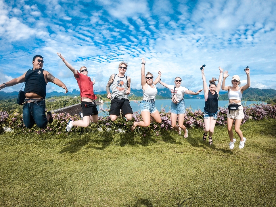 Group jumping with excitement on a scenic hilltop.