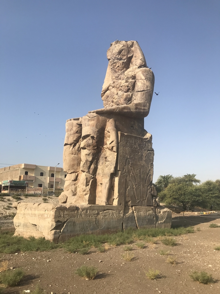 Large ancient statue in an outdoor setting.