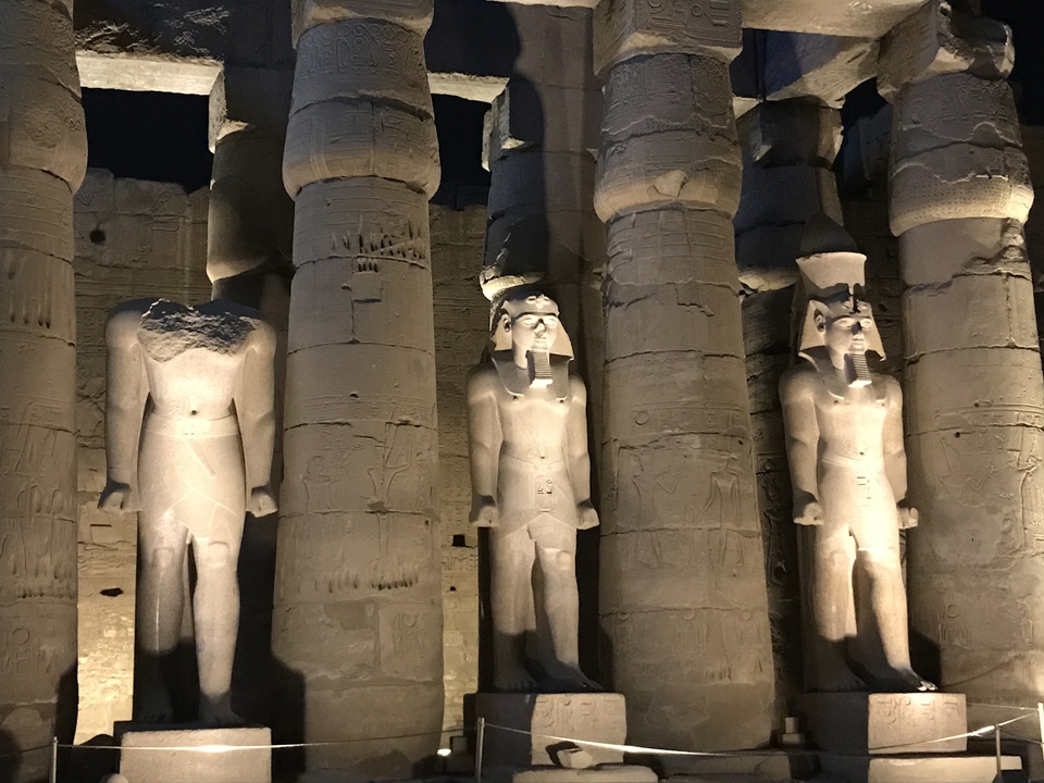 Night view of ancient Egyptian columns and statues.