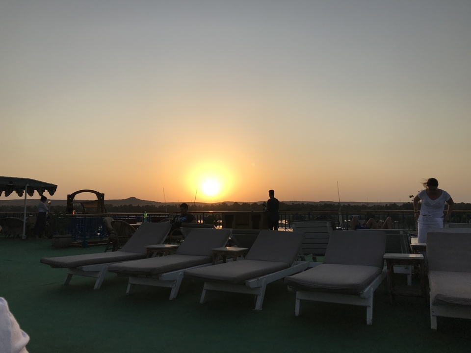 People relaxing on a rooftop during sunset.