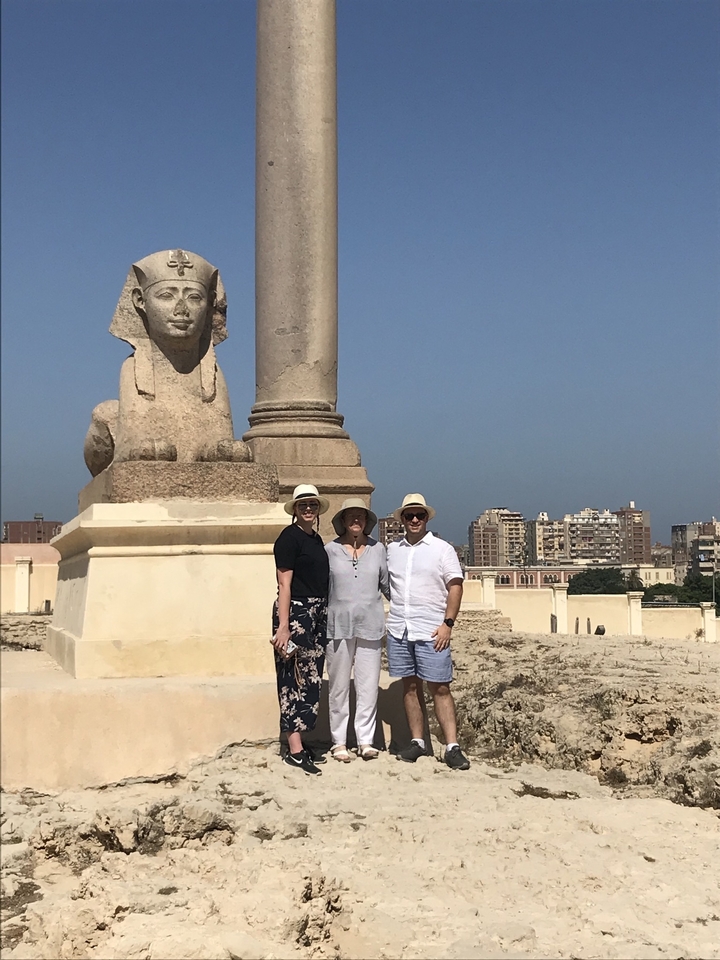 Group photo in front of a sphinx and ancient ruins.