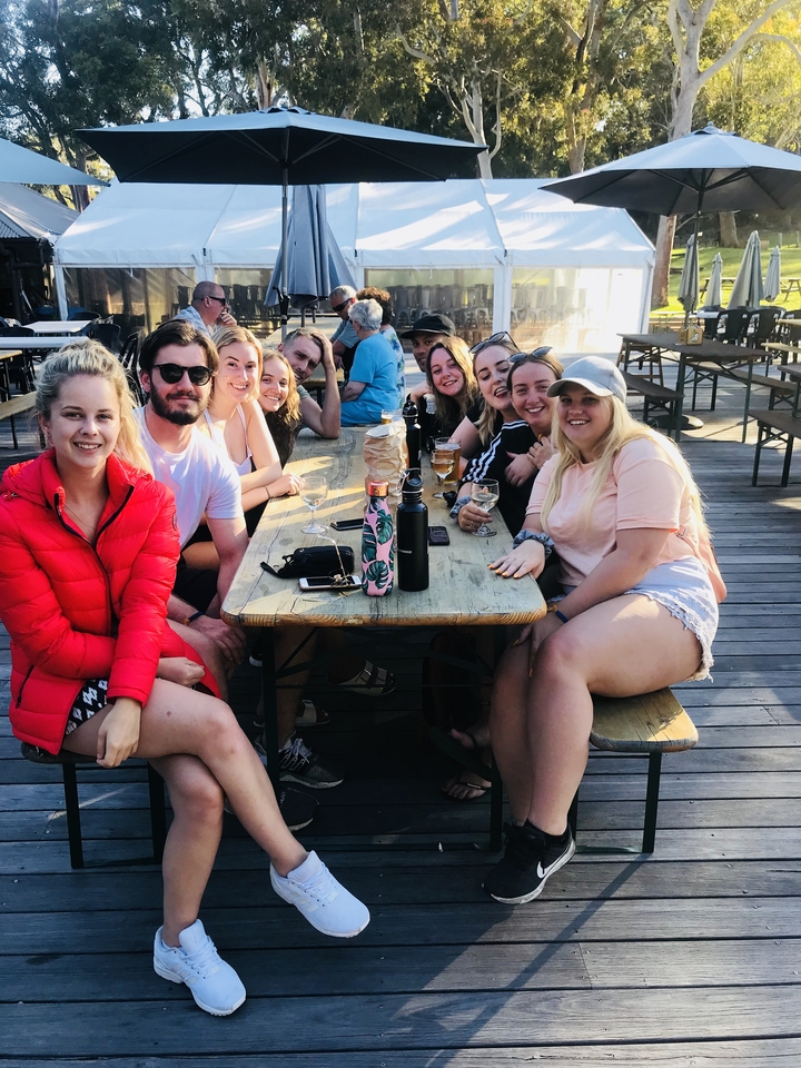 Groupe de personnes assises dans un espace de restauration en plein air.