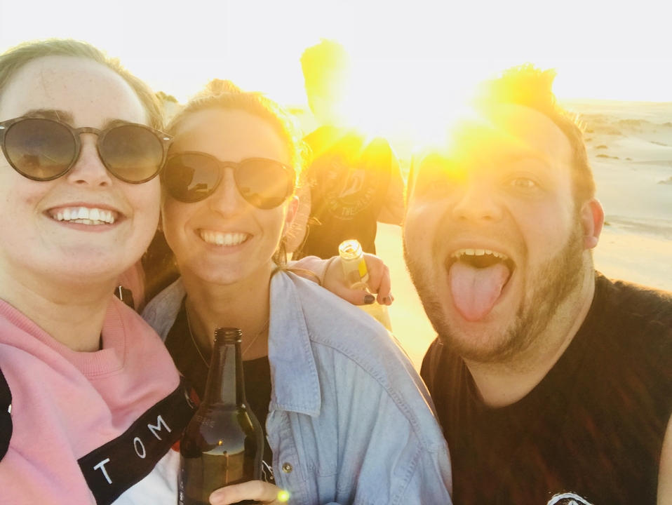 Selfie de groupe avec un soleil éclatant en arrière-plan.