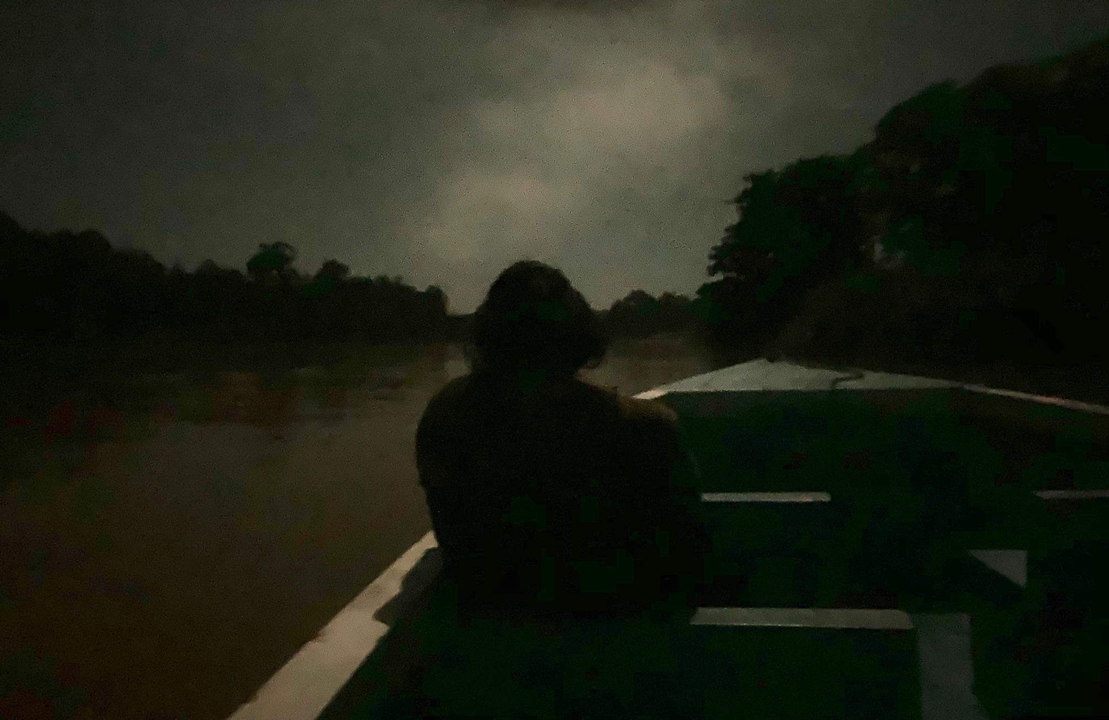 Silhouette d'une personne dans un bateau la nuit.