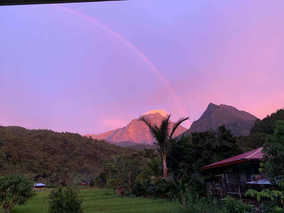 Montagne avec un arc-en-ciel et des couleurs de coucher de soleil.