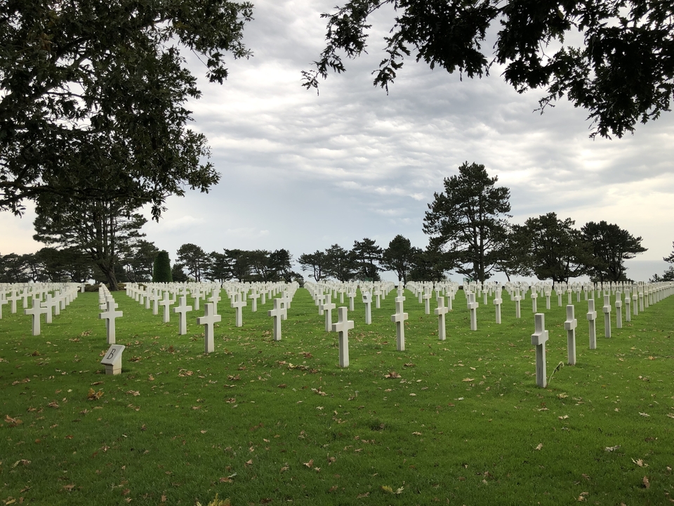 Cimetière militaire avec des croix blanches disposées en rangées.