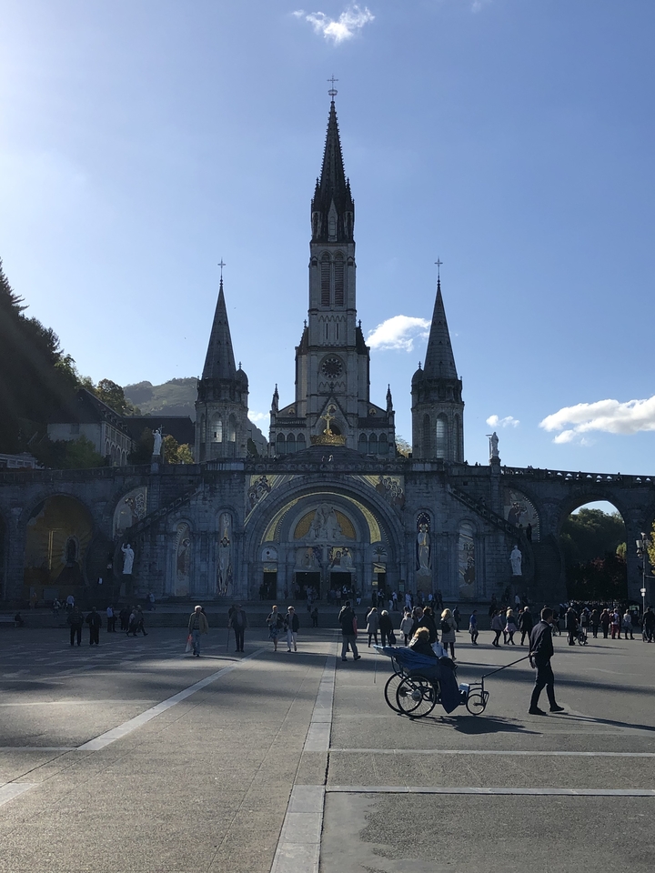 Basilique avec une façade ornée et des gens devant.