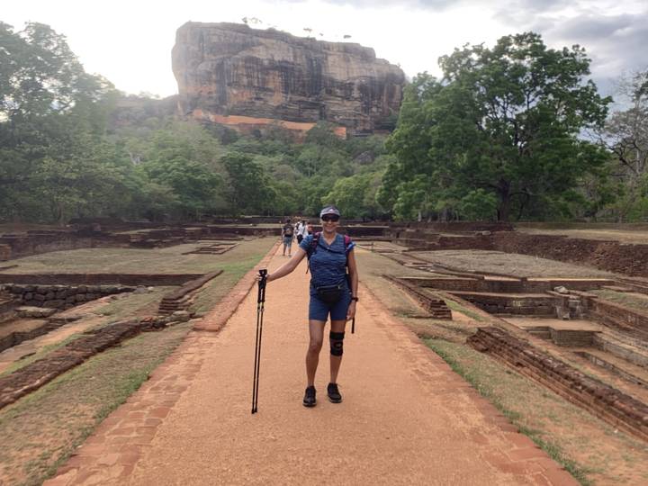 A person posing on a pathway leading to Sigiriya Rock Fortress.
