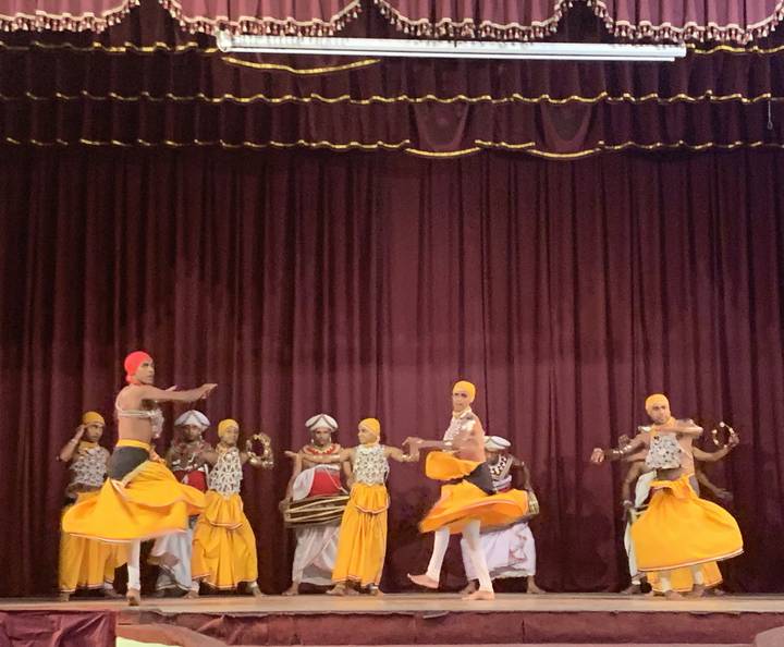 A traditional dance performance with dancers in colorful costumes on stage.
