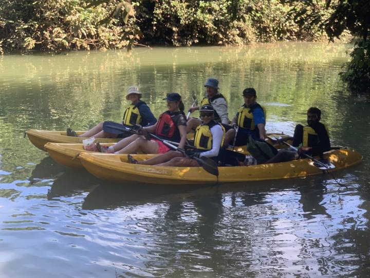 A group kayaking in calm waters with trees surrounding the area.