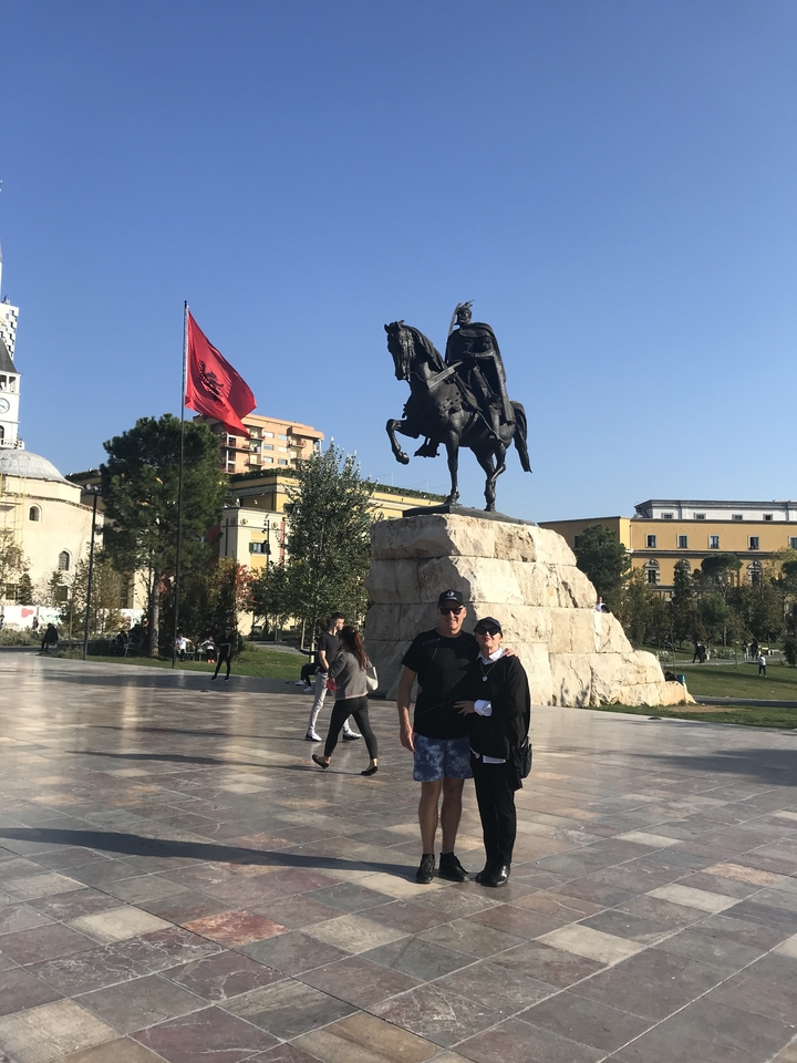 Statue d'une personne à cheval, avec des gens qui posent devant.