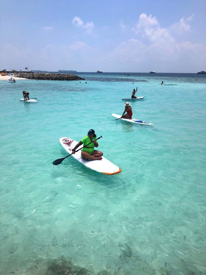 Des gens faisant du paddle sur des eaux turquoise cristallines.