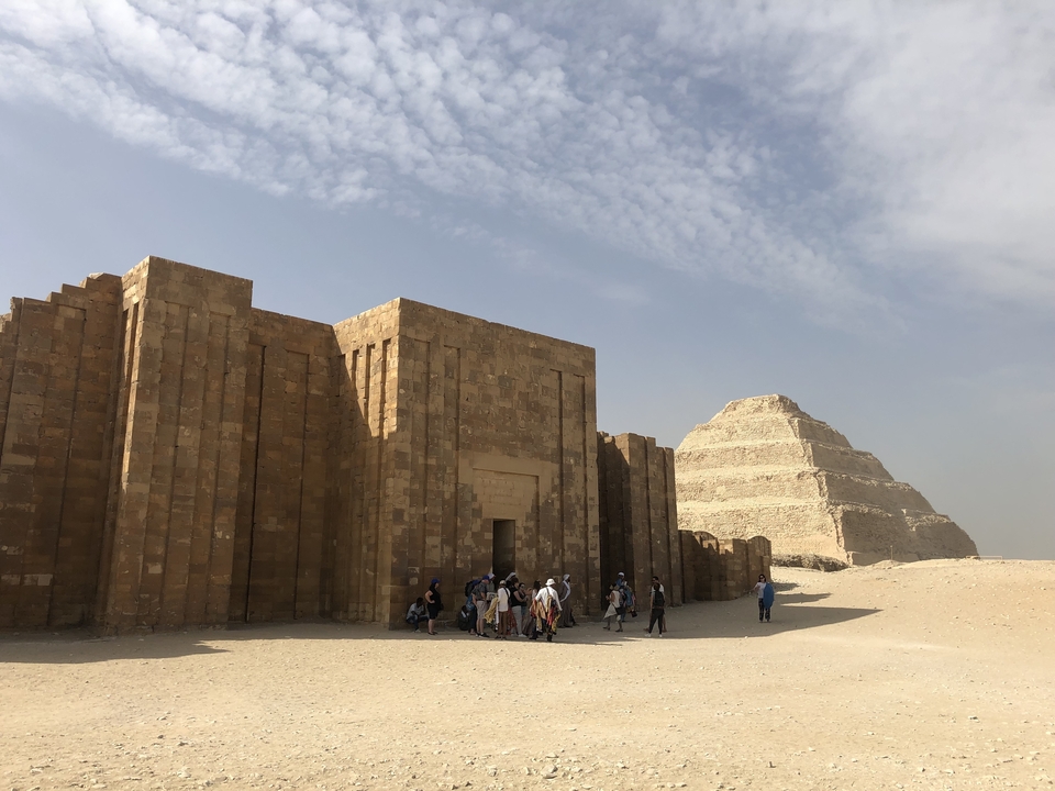 The Step Pyramid at Saqqarah with tourists exploring nearby.