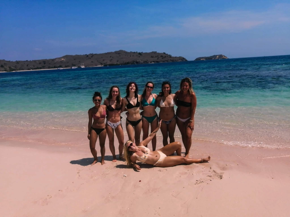 Groupe de personnes en maillots de bain sur une plage au bord de la mer.