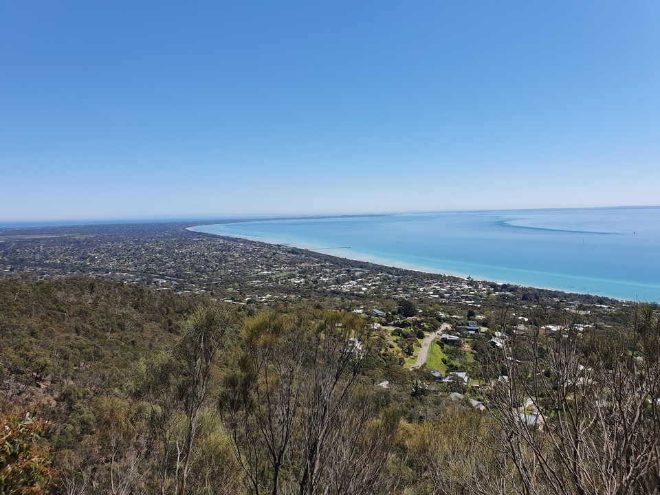 Coastal view with a long sandy beach and urban area.