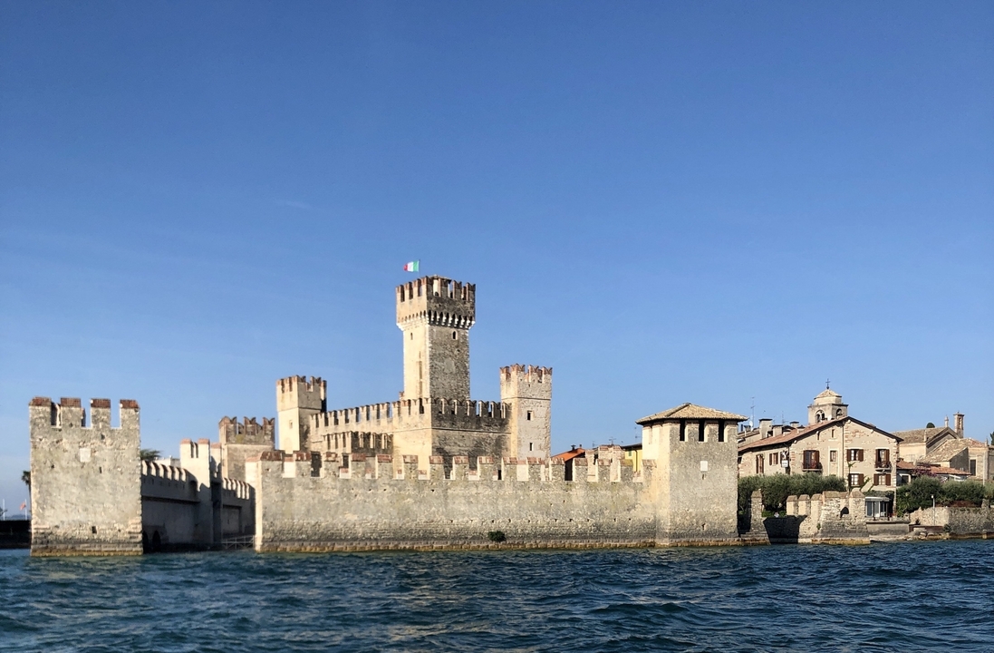 Old castle on a lake with the Italian flag.