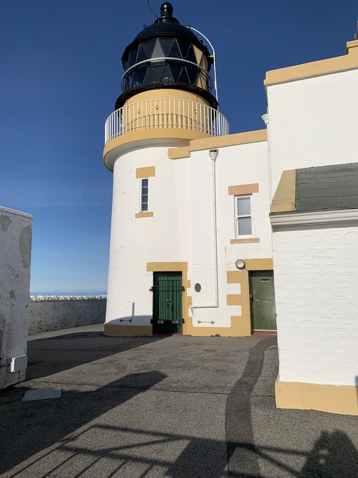 Structure de phare blanc contre un ciel bleu.