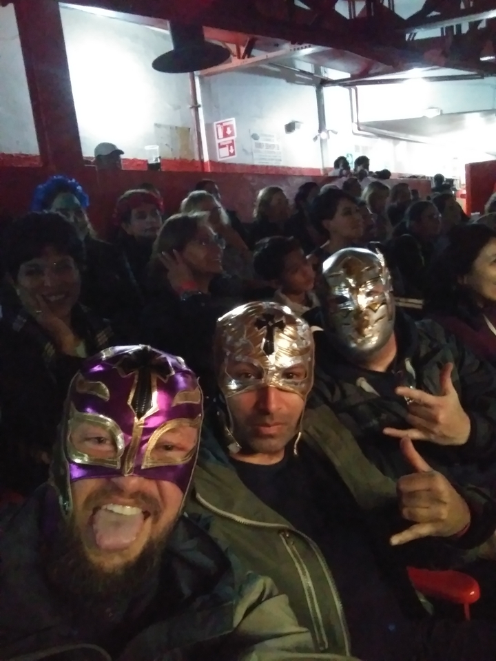 People wearing wrestling masks at an event.