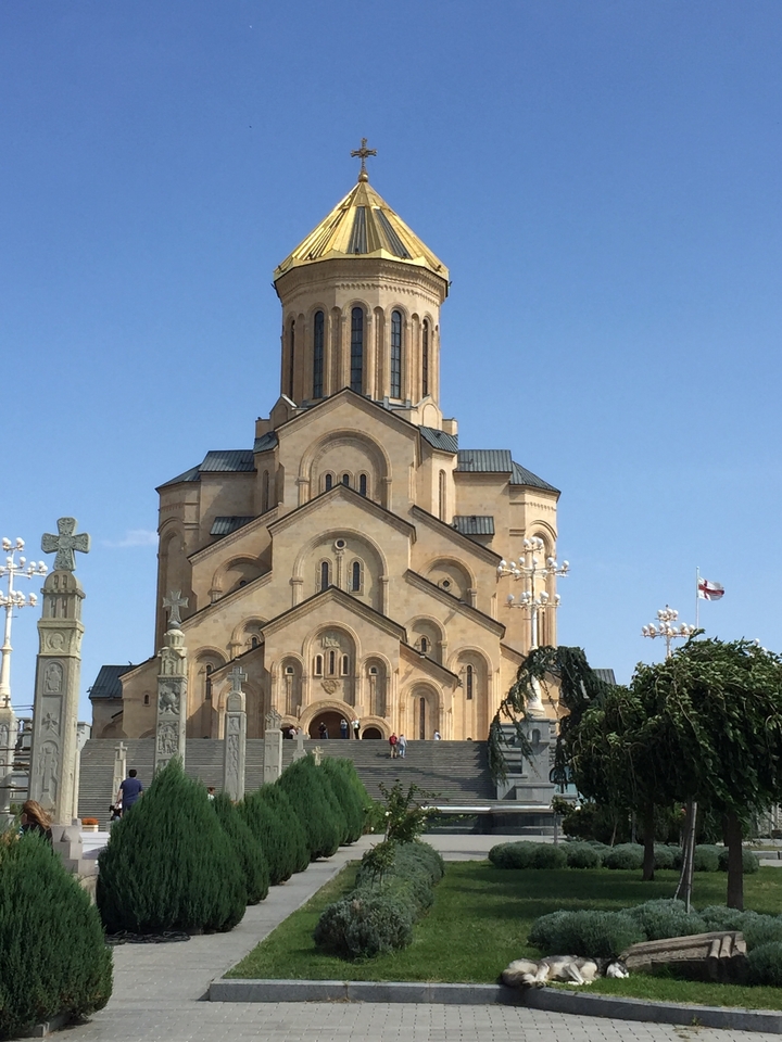 Grande cathédrale avec des croix décoratives environnantes.