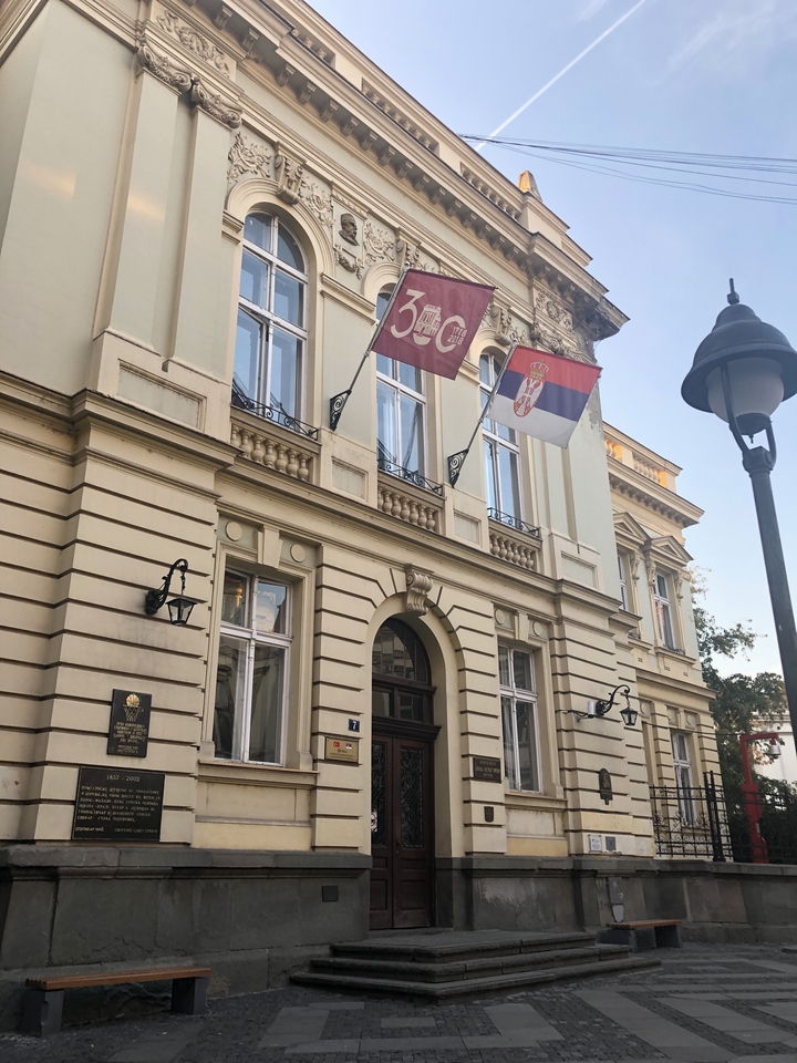 Street with historical building and flags.