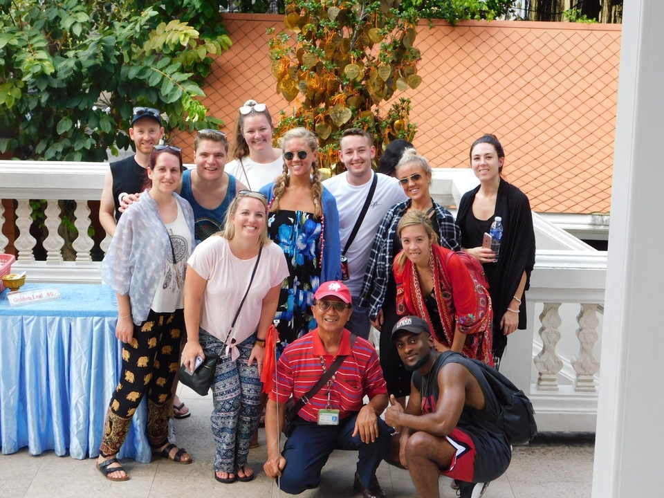 Group of people posing for a photo with buildings in the background.