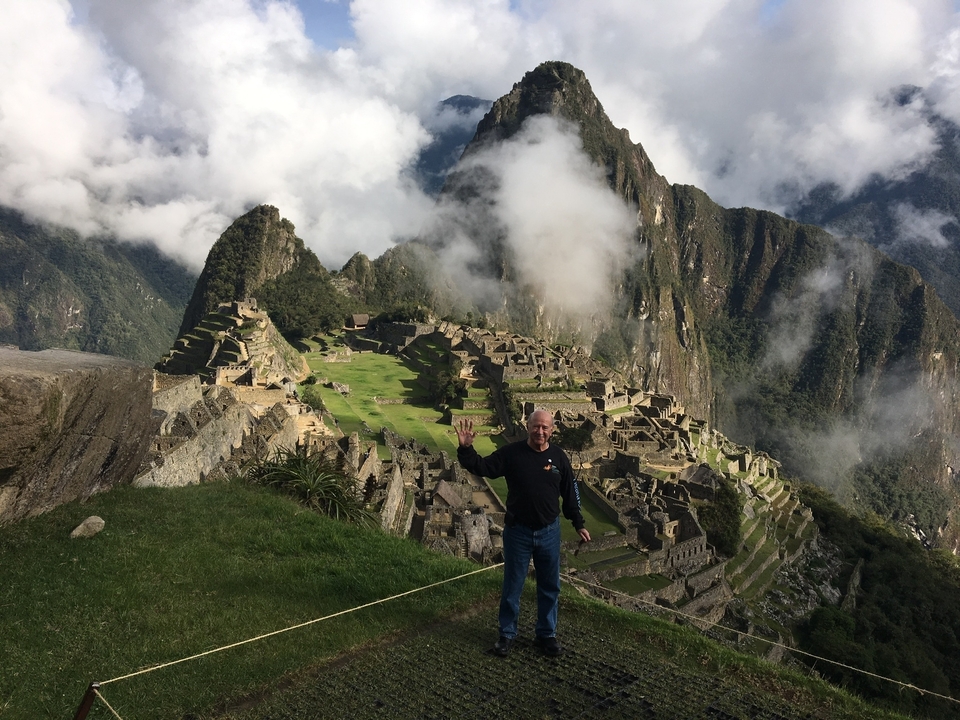 Personne debout devant le Machu Picchu avec des montagnes pittoresques.
