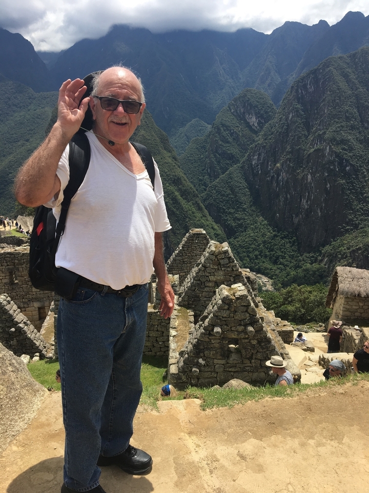 Gros plan d'une personne devant des structures de pierre anciennes.