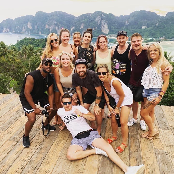 Group of friends posing with a tropical landscape in the background.