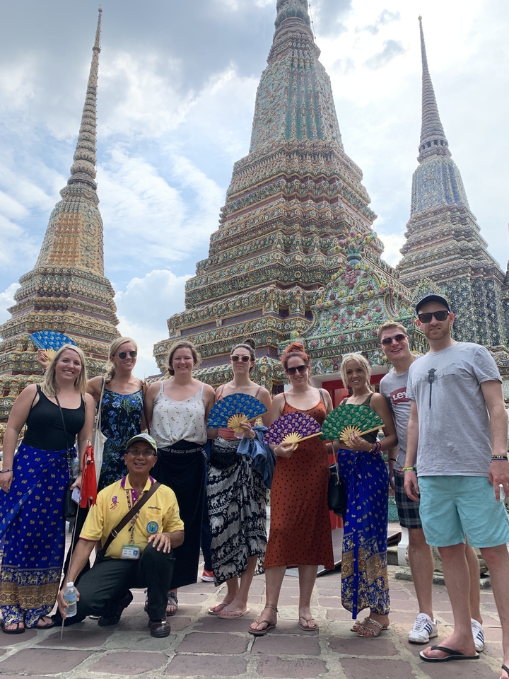 Tourists posing in front of ornate temples.