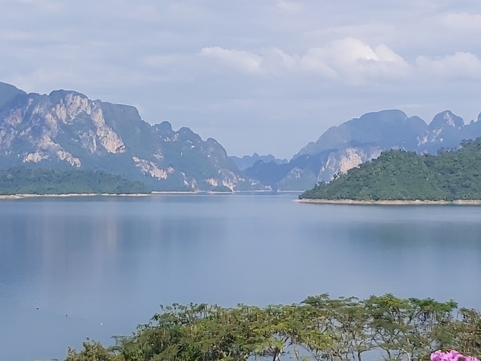 Mountains with lush greenery reflected in a calm lake.
