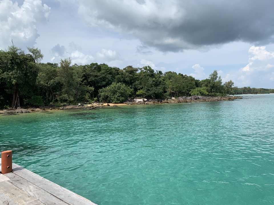 Clear blue water with a forested island in the distance.