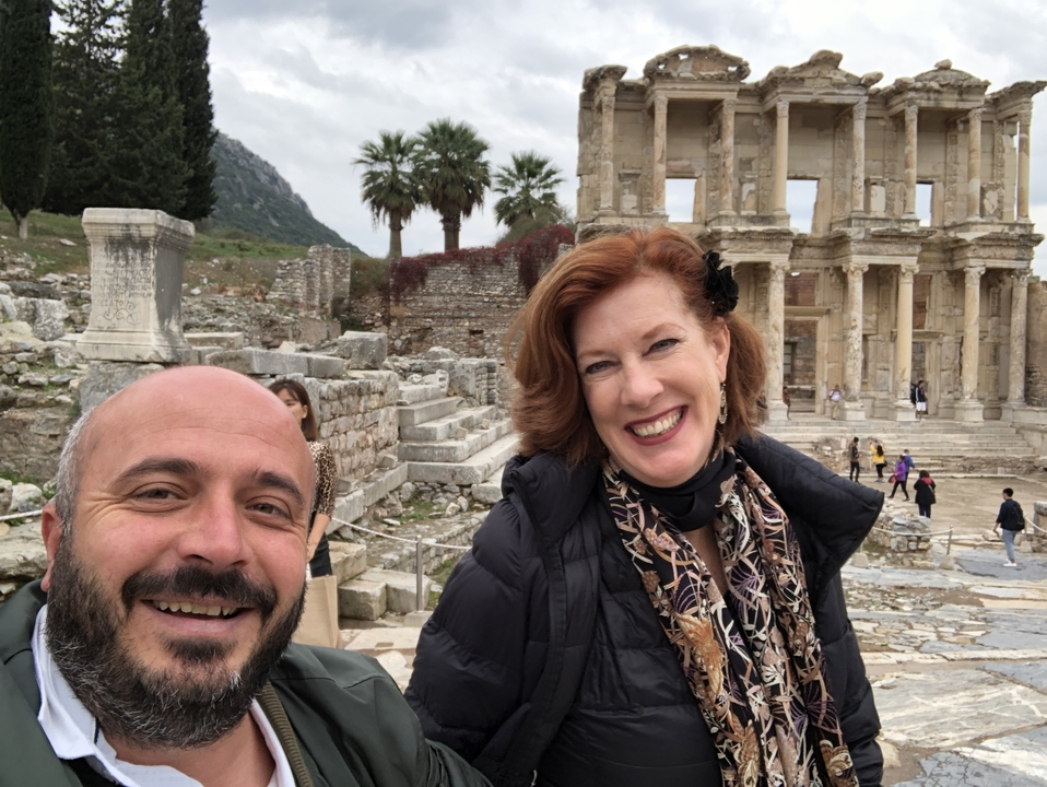 Deux personnes souriantes devant des ruines antiques.
