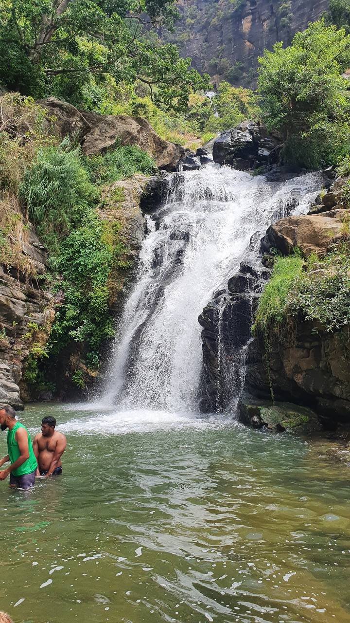 Waterfall with people swimming at the base.